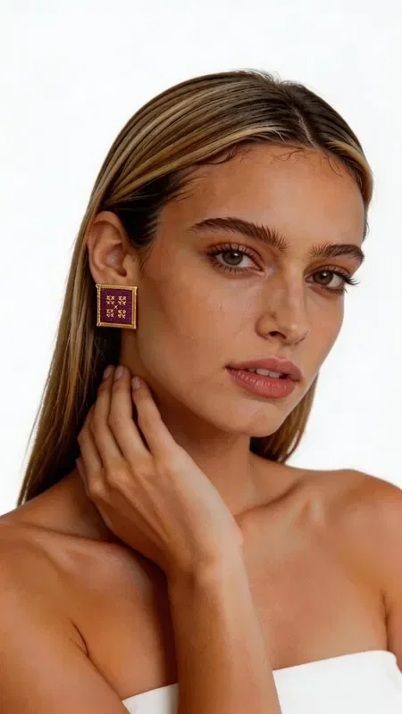 These statement embroidered earrings with geometric patterns in gold thread on a stunning burgundy background add a unique touch of elegance to every look. Designed by Greek Jewelry Designer Aikaterini Chalkiadaki, these striking handmade earrings combine the traditional art of embroidery with contemporary design.

Each earring is crafted with special attention to detail, using gold thread that forms geometric motifs on a deep burgundy background. The square shape with a gold outline offers a modern interpretation of classic embroidery, ideal for women who love statement jewelry.

These unique earrings are perfect for special occasions such as weddings, evening outings, or professional events. They pair beautifully with monochrome outfits, adding color and elegance.

Material: Brass, Fabric
Care: Store in a dry place and avoid contact with water and chemical products to preserve the colors.