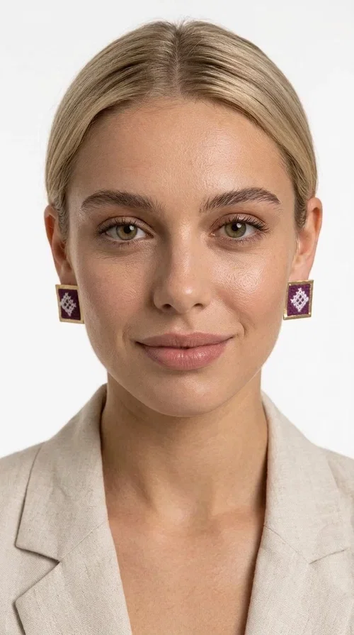 The embroidered statement earrings with geometric patterns in magenta are the ideal choice for every woman who wants to express herself through unique, handmade jewelry. Designed by Greek Jewelry Designer Aikaterini Chalkiadaki, these striking stud earrings combine the traditional art of embroidery with a modern aesthetic result, creating a piece of jewelry that truly stands out.

Each pair consists of square earrings with gold brass framing embroidered fabric in a vivid magenta color, decorated with delicate geometric motifs in white — a combination that evokes folklore aesthetics and Greek tradition. The result is a jewelry piece with character, instantly elevating any look, from casual outfits to formal events.

Ideal for weddings, christenings, summer events, or everyday looks you want to make a statement with, these handmade earrings pair perfectly with white, ecru, or monochrome outfits.
