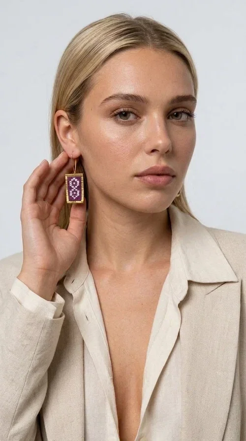 The embroidered statement earrings with geometric designs in magenta are the ideal choice for every woman who wants to stand out with style and character. Designed by Greek Jewelry Designer Aikaterini Chalkiadaki, these handmade earrings combine the traditional art of embroidery with a modern, striking result that won't go unnoticed.

Each pair features a rectangular shape with gold-tone brass elegantly framing the embroidered fabric, creating an impressive result that evokes Greek folk tradition. The geometric motifs in deep magenta and lilac give the earrings a boho-chic character that suits both everyday looks and formal occasions, such as weddings, christenings, and festive events.

Wear them with a simple white shirt to draw attention to your face, or pair them with a boho dress for a complete, harmonious outfit. These dangling hoop earrings belong to the category of statement jewelry that elevates any look to another level.