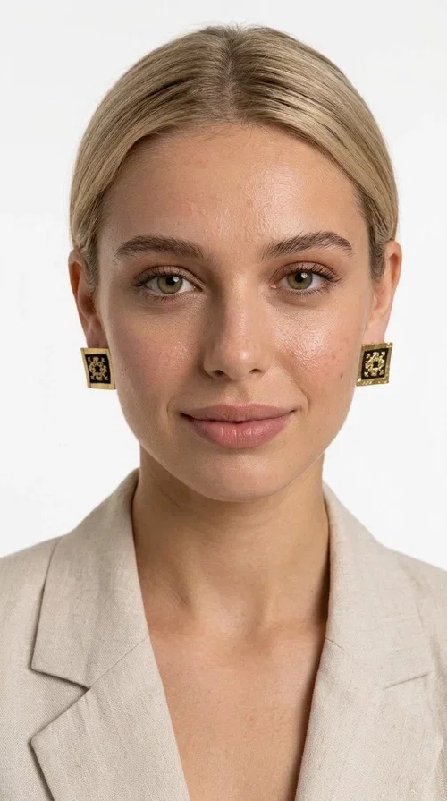 The embroidered statement earrings with geometric patterns in black are the ideal choice for those seeking an accessory that combines folk tradition with modern aesthetics. Designed by Greek Jewelry Designer Aikaterini Chalkiadaki, these handmade earrings are a small wearable work of art.

Each pair is made of brass and fabric, with embroidered motifs inspired by Greek folk art. Their square, flat shape and golden geometric patterns set against a black background create a striking visual contrast, making them stand out in any look. These stud earrings suit both casual and formal outfits equally well.

Wear them with a simple everyday look to instantly elevate it, or choose them for a wedding, an evening out, or a professional event. They also make a wonderful gift idea for women who appreciate handmade jewelry with character.