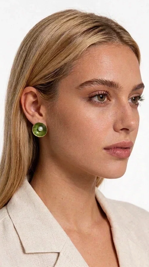 Khaki pearl stud earrings are the ideal choice for every woman seeking elegance with character. Designed by Greek Jewelry Designer Aikaterini Chalkiadaki, these handmade earrings combine the beauty of pearls with the earthy aesthetic of khaki enamel, creating a jewelry piece with strong personality.

Their round shape, crafted in deep khaki green enamel on brass, gains a special charm thanks to the central pearl that stands out with its white shine. The delicate textured pattern of the enamel adds depth and movement, making each pair unique. They are comfortable to wear thanks to the secure post fastening, while their size is ideal — striking enough to become the focal point of your look, without being overwhelming.

They pair equally well with casual everyday looks and more formal outfits, and they also make an excellent choice as a bridal accessory or a gift for special occasions.