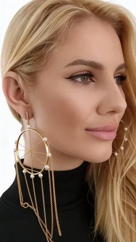 Discover the magic of large statement dangle earrings with pearls that will transform every look. These unique handmade "Dreamcatcher" earrings, designed by Greek Jewelry Designer Aikaterini Chalkiadaki, combine contemporary aesthetics with traditional Greek craftsmanship.

Made from high-quality brass with a golden finish, the earrings feature a geometric circle design adorned with natural pearls. The dangling chains create an elegant movement that catches every eye, while their statement design makes them ideal for special occasions.

These long earrings pair perfectly with evening outfits, bridal looks, or boho chic ensembles, adding a touch of luxury and mystery. Their ergonomic construction ensures all-day comfort.