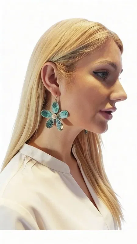 Large statement dangle earrings with pearls that combine boho style with a modern aesthetic. These unique handmade women's flower earrings, designed by Greek Jewelry Designer Aikaterini Chalkiadaki, stand out for their modern patina finish that creates striking green tones with golden accents.

Each earring is shaped like a daisy with six oval petals made of oxidized brass, while the center holds a natural pearl that adds elegance and light. The oxidized brass technique gives unique color variations that make each piece one of a kind. Their size makes these impressive earrings the ideal choice for weddings or special occasions.

Perfect for pairing with boho outfits or adding a pop of color to monochrome looks.