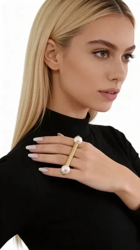 Discover the perfect balance between modern design and classic elegance with this striking statement ring featuring a pearl. Designed by Greek Jewelry Designer Aikaterini Chalkiadaki, this handmade ring combines a contemporary aesthetic with the timeless charm of pearls.

The ring's unique geometric shape in a gold hue creates a refined base for the two natural pearls that adorn its ends. The open construction offers flexibility in fit, while the modern design makes it ideal for both casual and more formal looks.

This women's pearl ring is the perfect choice for those seeking handmade jewelry that stands out. The quality of Greek craftsmanship is evident in every detail, from the metalwork to the placement of the pearls. Store in a dry place and clean gently with a soft cloth to preserve the shine of the pearls and the metal.