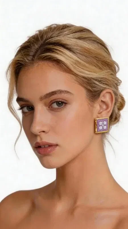 These embroidered statement earrings with geometric patterns in a lilac shade will become your favorite accessory for every special occasion. Designed by Greek Jewelry Designer Aikaterini Chalkiadaki, these striking handmade earrings combine the traditional art of embroidery with contemporary design. The square shape with intricate geometric motifs creates a unique visual effect, while the gold thread adds shine and elegance. The romantic lilac color highlights femininity and offers versatility when pairing with different outfits. These modern embroidered earrings are ideal for weddings, evening outings, and for elevating your everyday look. The handmade construction guarantees the uniqueness and quality of each piece.

Material: Brass, Fabric

Care: Store the earrings in a dry place and avoid contact with water and cosmetics to preserve the shine of the gold thread.