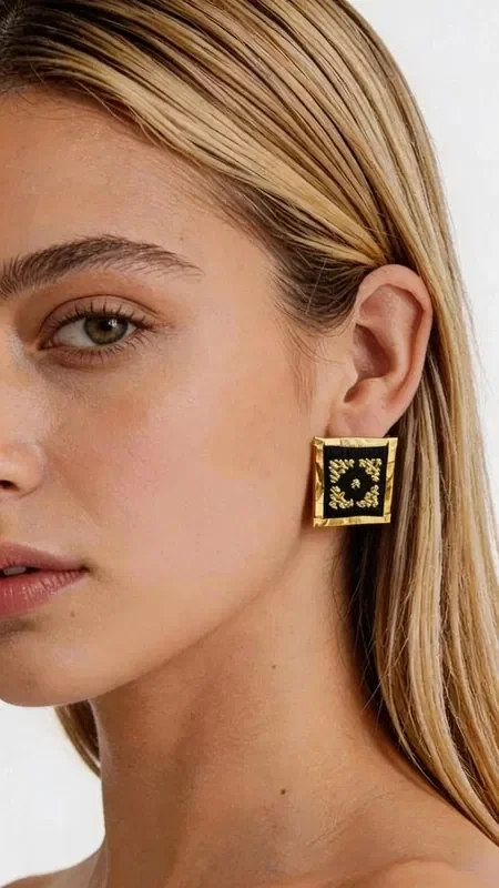Stand out with these striking statement embroidered earrings that combine traditional Greek embroidery art with a modern geometric design. Designed by Greek Jewelry Designer Aikaterini Chalkiadaki, these unique handmade earrings feature a rich gold-thread embroidered pattern on an elegant black background.

Each earring is a small work of art, with intricate geometric motifs that create a stunning visual effect. The gold thread shines beautifully against the black base, offering an impressive combination that suits both everyday and formal looks.

These modern dangle earrings are ideal for women who love original jewelry with a Greek character. Their square shape offers a contemporary aesthetic, while the embroidered detail brings tradition to the forefront.

Material: Brass, Fabric

Take care of your earrings by storing them in a dry place and avoiding contact with moisture and chemical products.