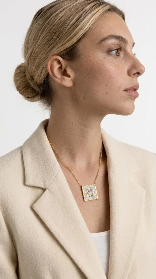 The embroidered necklace with geometric patterns is a statement piece of jewelry that combines the traditional art of embroidery with a modern, minimal aesthetic. Designed by Greek Jewelry Designer Aikaterini Chalkiadaki, this necklace is a handmade piece with strong character — ideal for women who appreciate authenticity and want to stand out.

The square pendant is adorned with white embroidery in geometric motifs inspired by folk tradition, while the gold-toned brass frame adds warmth and elevates the level of elegance. The gold-tone chain blends softly into the overall look, creating a piece of jewelry that suits casual looks just as well as formal occasions.

Wear it over a white t-shirt or under a blazer for an effortless chic look. It also makes a wonderful gift for women who love handmade jewelry with a Greek identity.