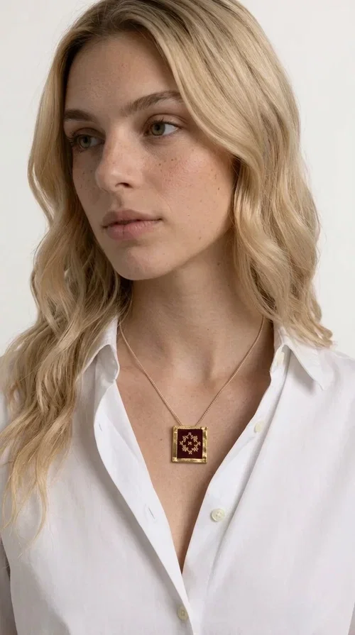 The embroidered burgundy necklace with geometric patterns is a statement piece that combines the traditional art of embroidery with a contemporary aesthetic, creating a unique result that instantly catches the eye.

Designed by Greek Jewelry Designer Aikaterini Chalkiadaki, this handmade necklace features a square brass pendant with deep burgundy fabric and a striking embroidered geometric motif inspired by Greek folk tradition. The gold-toned brass metal frame surrounds the embroidery, giving the piece a vintage, luxurious feel. The delicate gold-tone chain highlights the pendant, making it the ultimate focal point of any look.

Ideal for pairing with a casual white shirt, a dress, or elegant attire for an evening out, this necklace is equally suited to everyday and formal occasions. It also makes an excellent gift choice for loved ones who appreciate unique, handmade jewelry with a Greek soul.