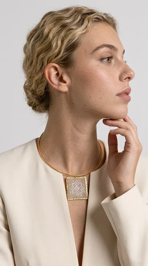 The statement necklace embroidered with geometric patterns is a jewelry piece that instantly grabs attention — bold, handmade and full of character. Designed by Greek Jewelry Designer Aikaterini Chalkiadaki, it combines the tradition of embroidery art with a modern aesthetic result that suits both day and evening wear. The brass collar holds a square embroidered pendant in deep burgundy color, decorated with delicate geometric motifs inspired by Greek folk tradition.

This necklace is not just an accessory — it's a style statement. The embroidered fabric in burgundy shade, framed by golden brass, creates a striking contrast that enhances every outfit. Ideal to be worn over a simple white or ecru shirt, or to complete an evening look, it offers that unique balance between boho and minimal style.
